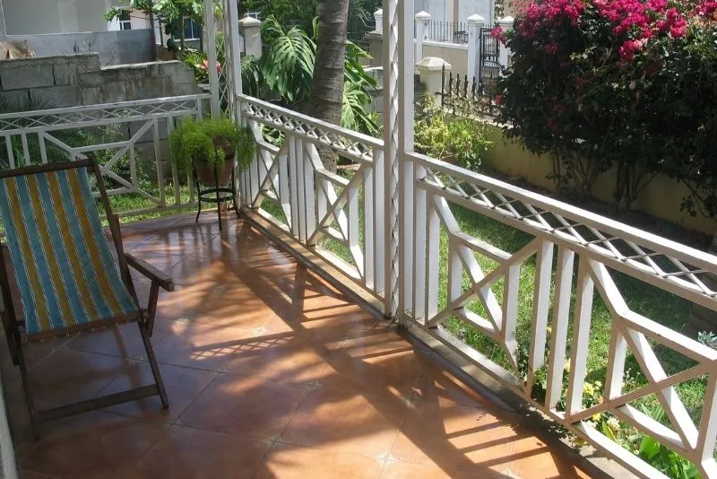 Tiled open verandah with a deck chair overlooking a lush garden