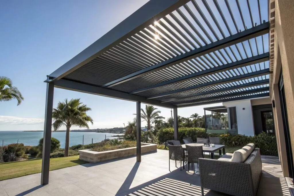 Weather-resistant aluminium pergola with charcoal finish overlooking Gold Coast waterfront, demonstrating durability in coastal environments while providing stylish outdoor living space protected from harsh UV radiation.