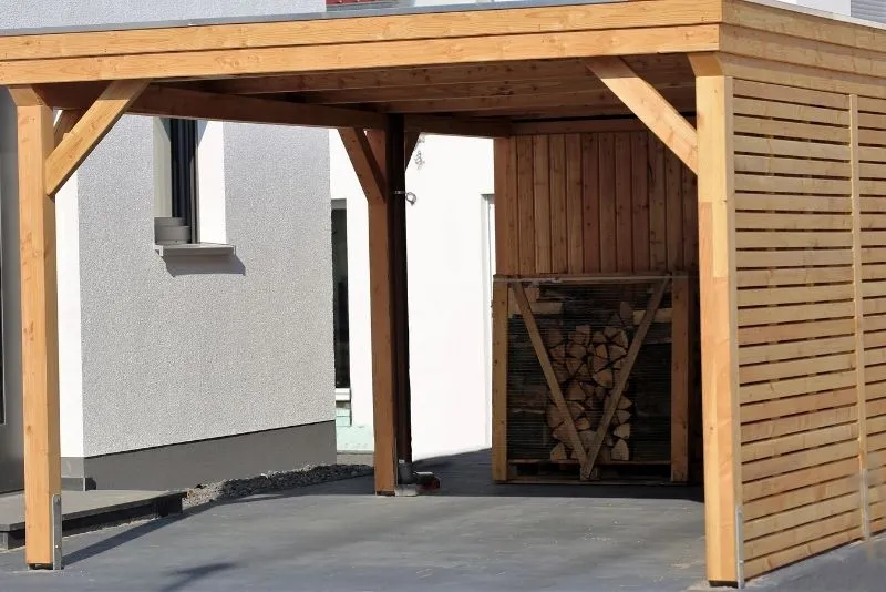 Open timber-framed carport attached to a home