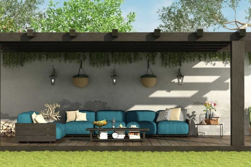 Pergola decorated with string lights, cushions and wall art