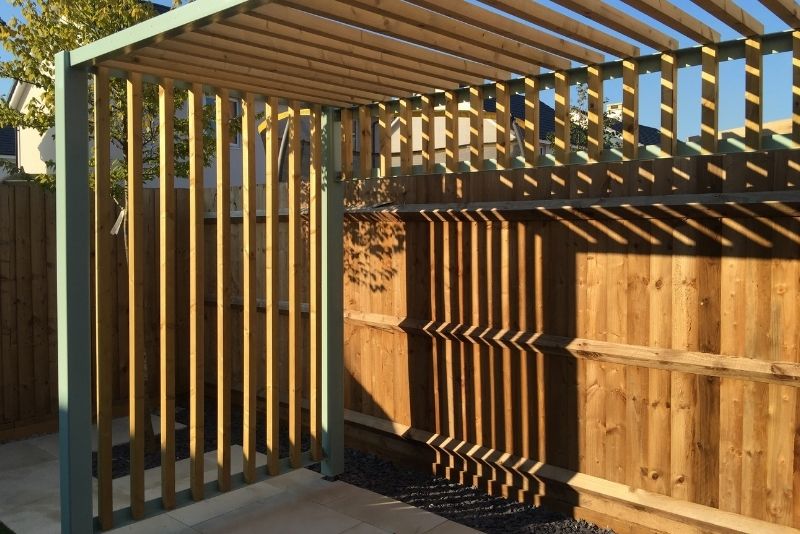 Pergola with trimmed vines and freshly treated timber