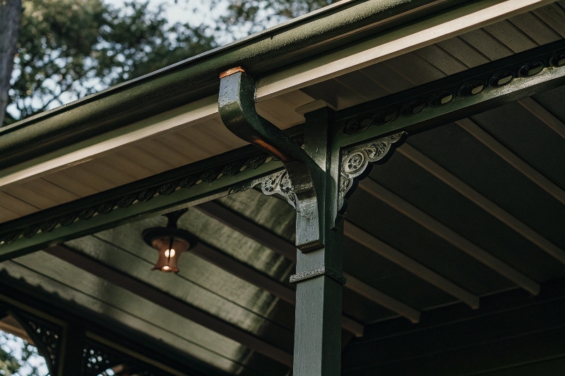 Detailed view of ornate timber joinery and decorative brackets on traditional Queenslander pergola with integrated outdoor lighting